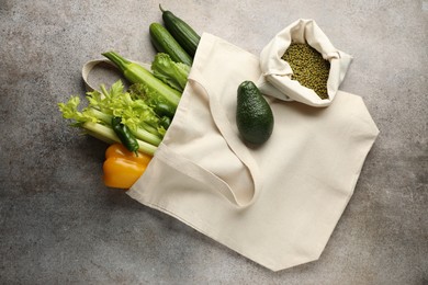 Photo of Shopper bag with products on grey background, top view. Eco friendly lifestyle