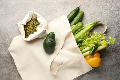 Photo of Shopper bag with products on grey background, top view. Eco friendly lifestyle