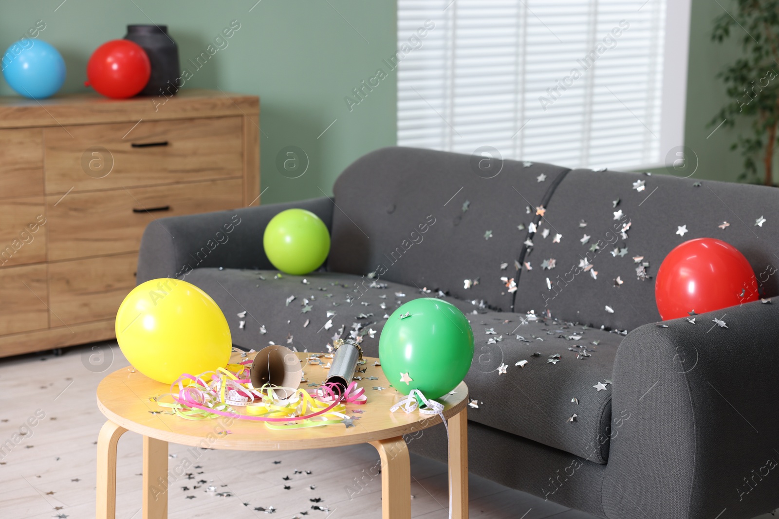 Photo of Shiny confetti, balloons and other party decor indoors