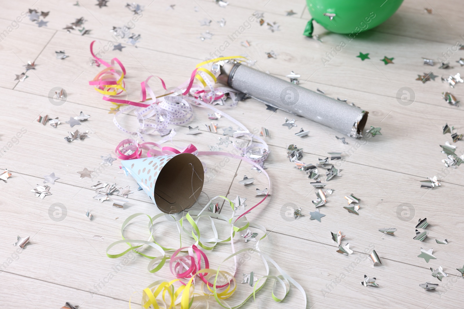 Photo of Confetti popper, serpentine streamers and other party decor on floor indoors