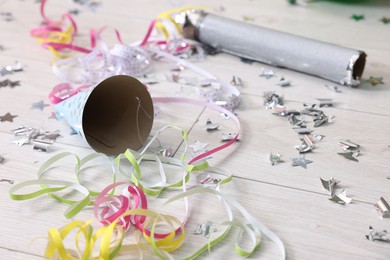 Photo of Shiny confetti, serpentine streamers and other party decor on floor indoors, closeup