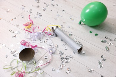 Photo of Confetti popper, serpentine streamers and other party decor on floor indoors