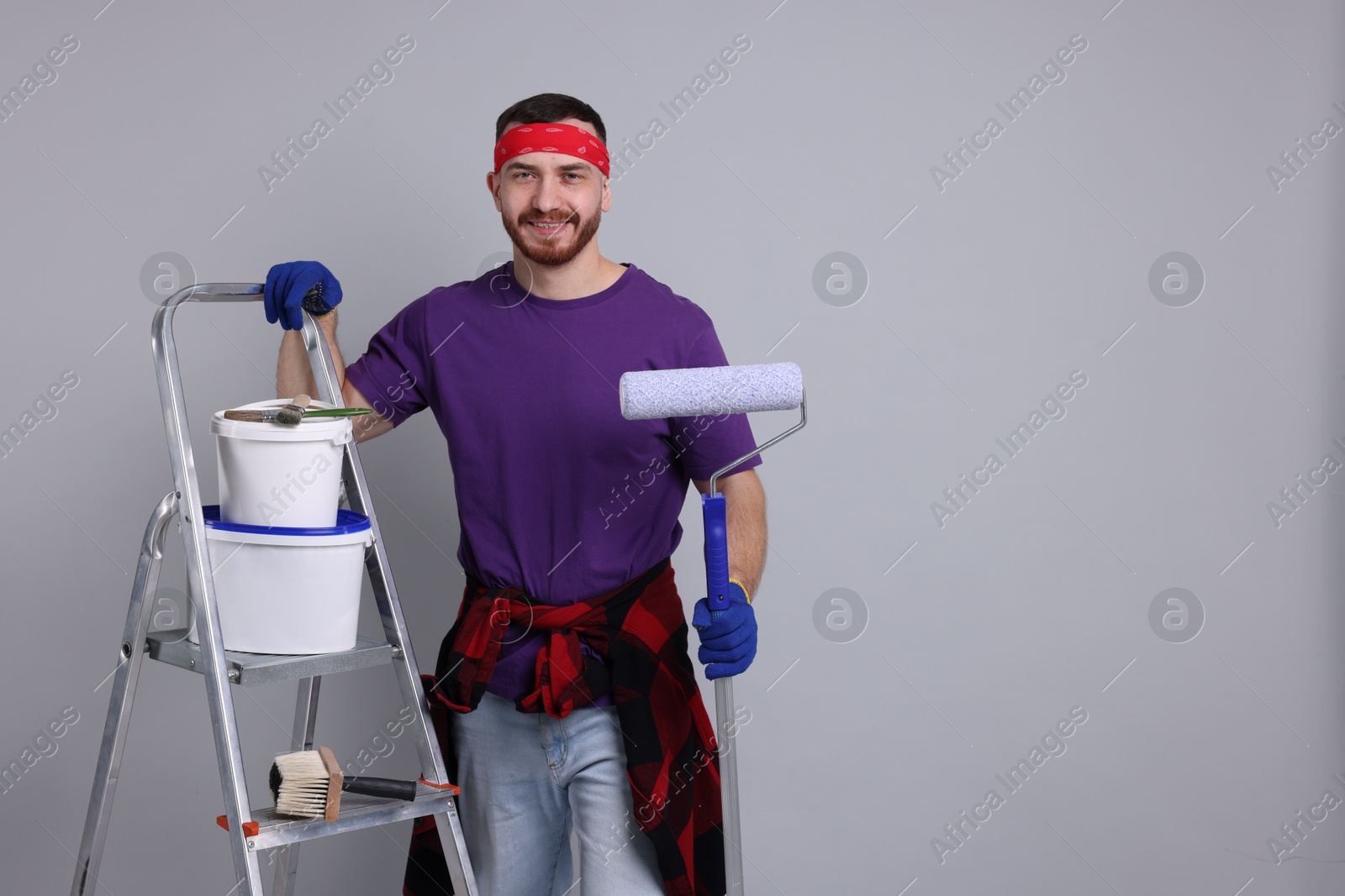 Photo of Man with tools and supplies on light grey background. Space for text