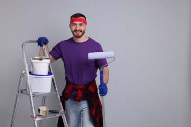 Photo of Man with tools and supplies on light grey background. Space for text