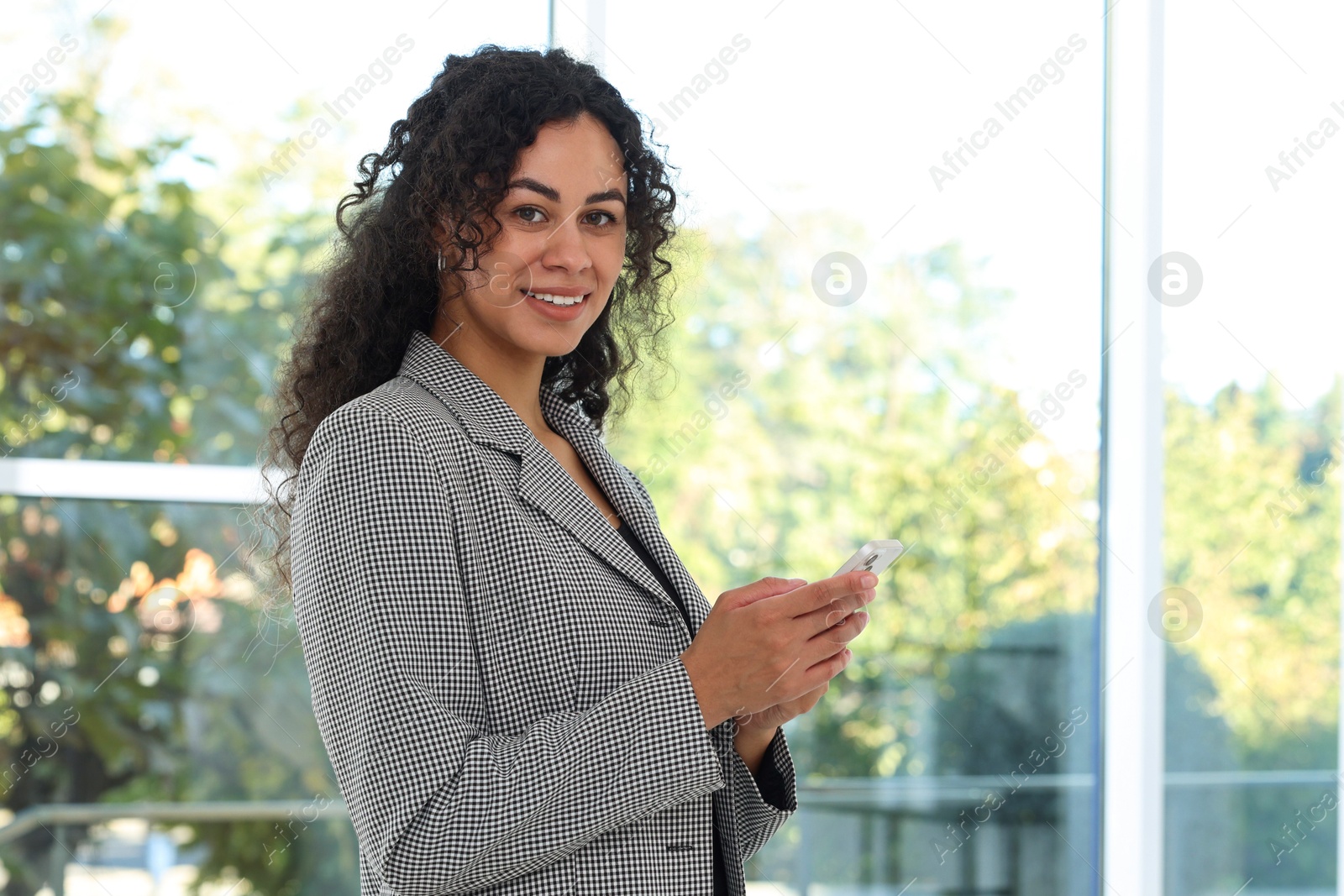 Photo of Portrait of young woman with phone wearing stylish suit indoors