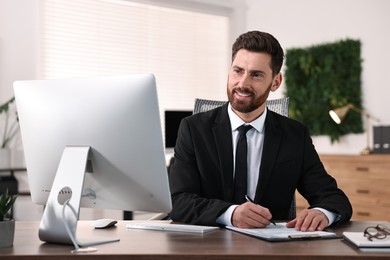 Photo of Man working with document at table in office