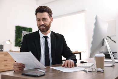 Photo of Man working with documents at table in office