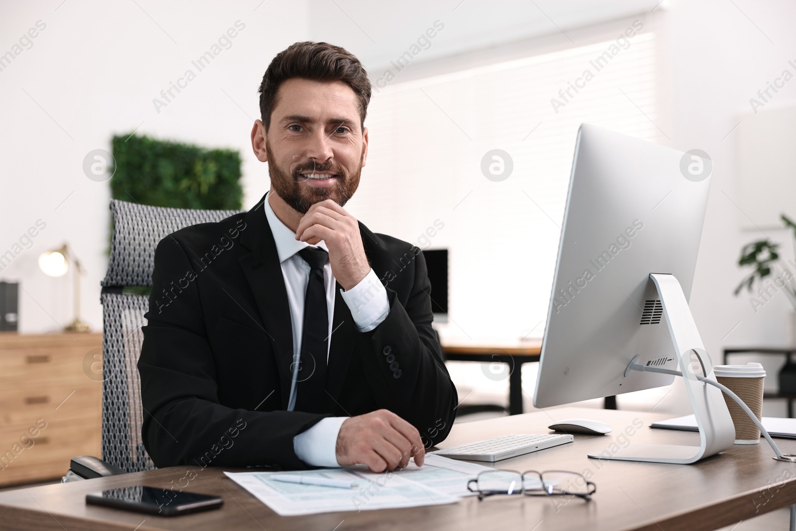 Photo of Man working with documents at table in office