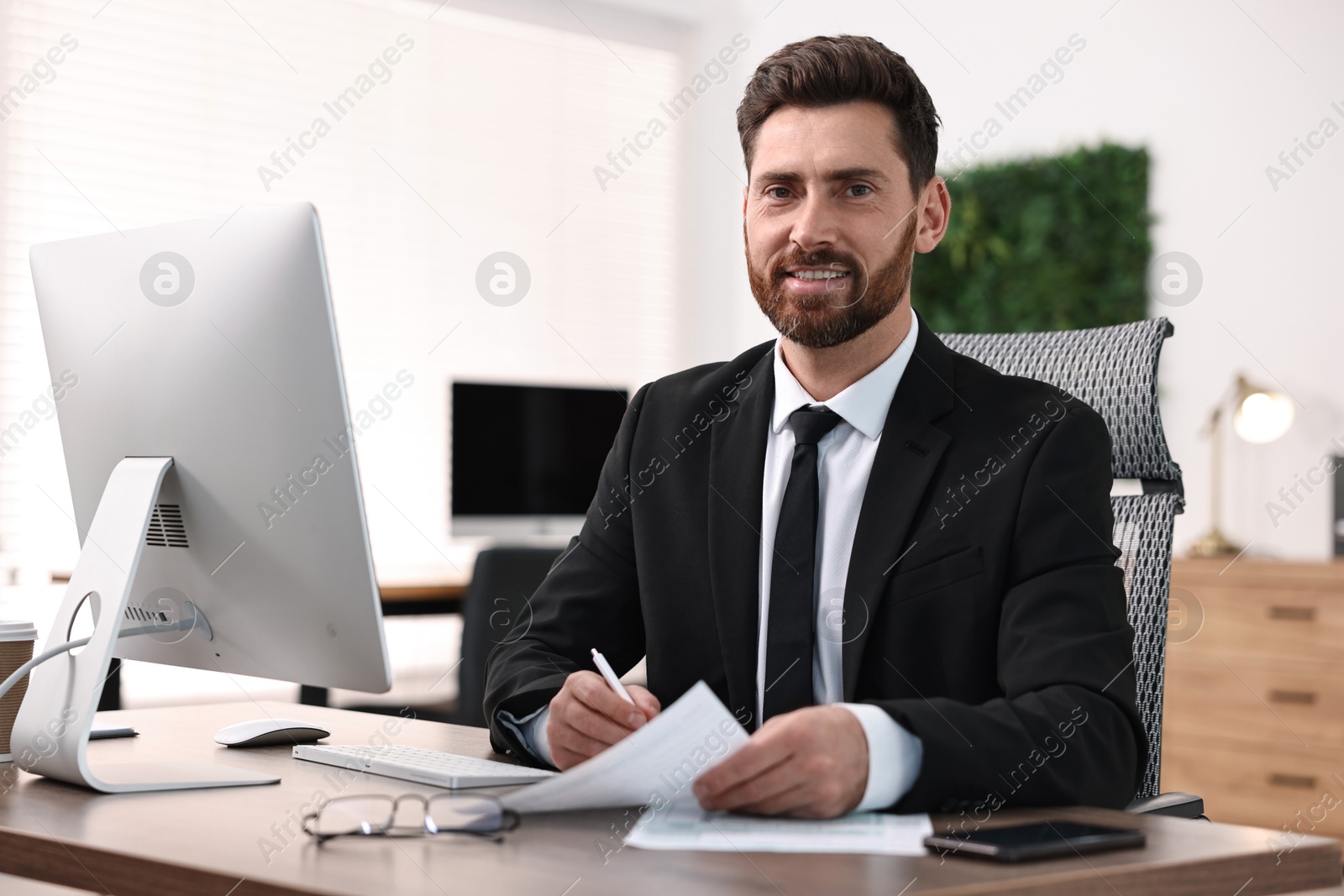 Photo of Man working with documents at table in office