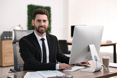 Photo of Man working on computer at table in office