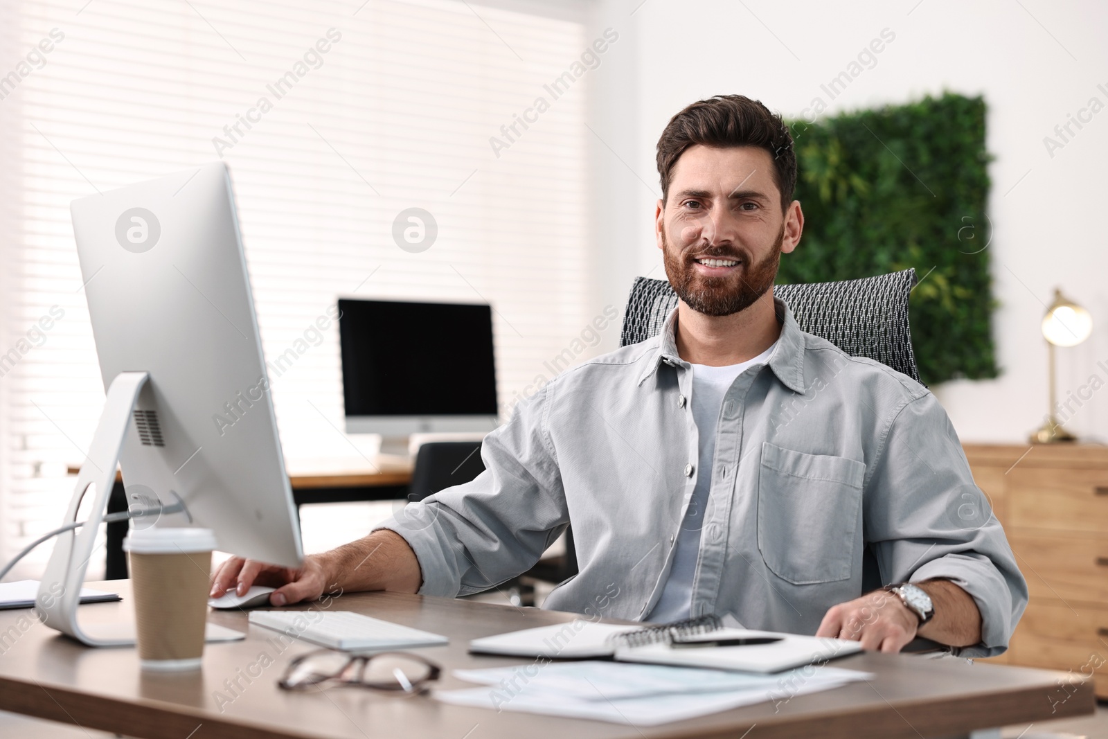 Photo of Man working on computer at table in office