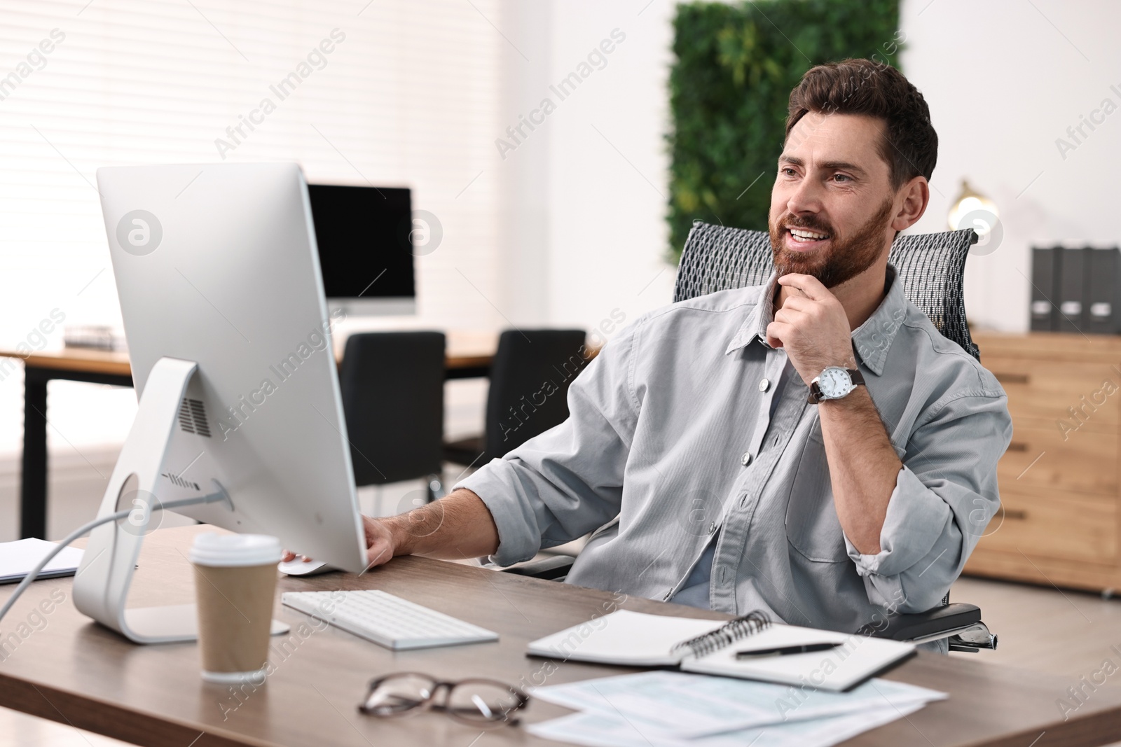 Photo of Man working on computer at table in office