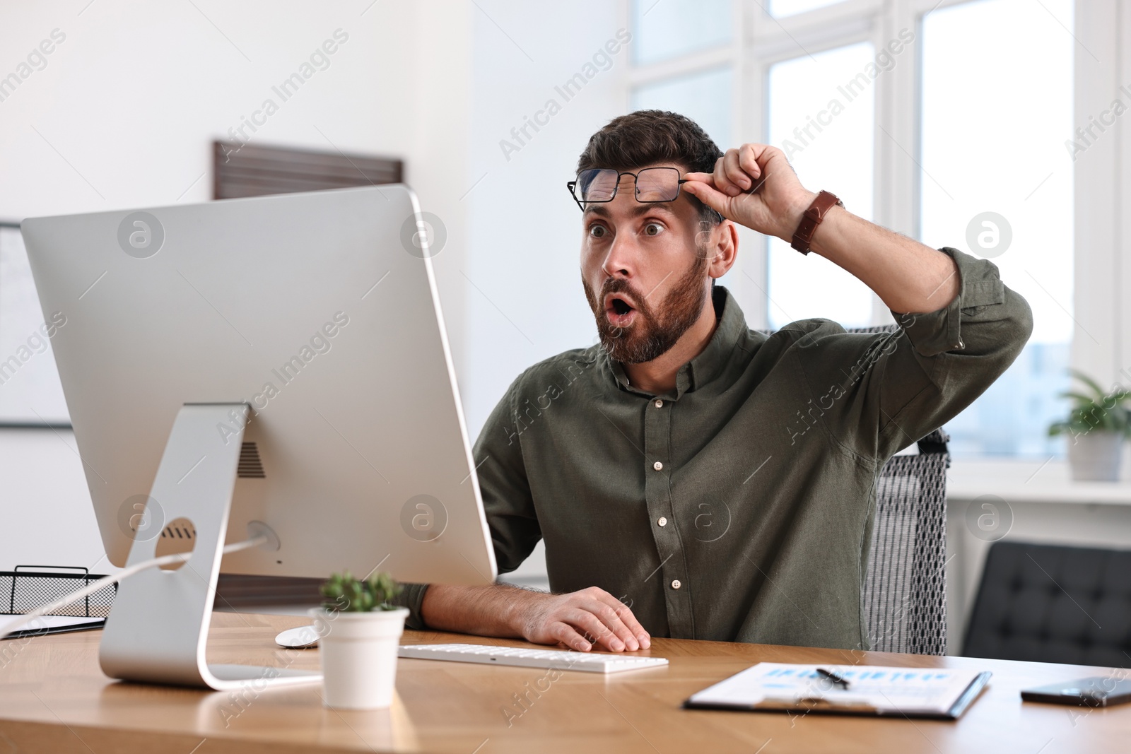 Photo of Man working with computer at table in office