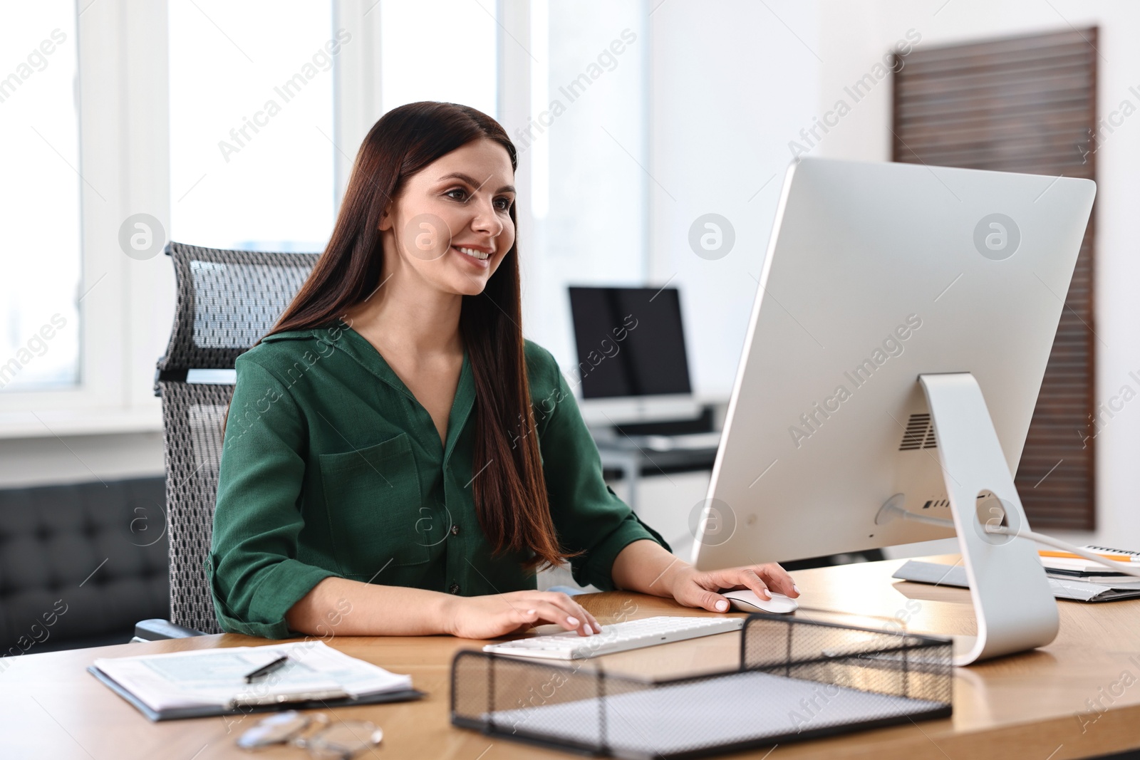 Photo of Woman working on computer at table in office