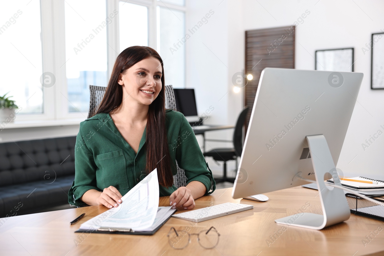 Photo of Woman working with document at table in office