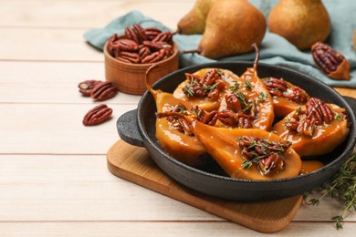 Photo of Delicious pears with caramel sauce, pecan nuts and thyme on wooden table, closeup. Space for text