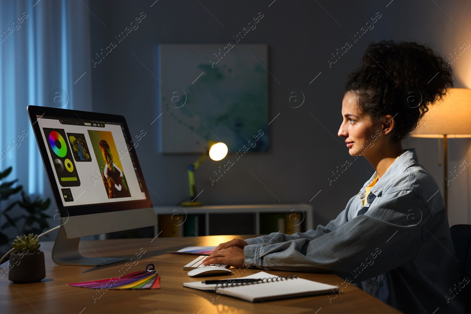 Photo of Designer working on computer indoors at night