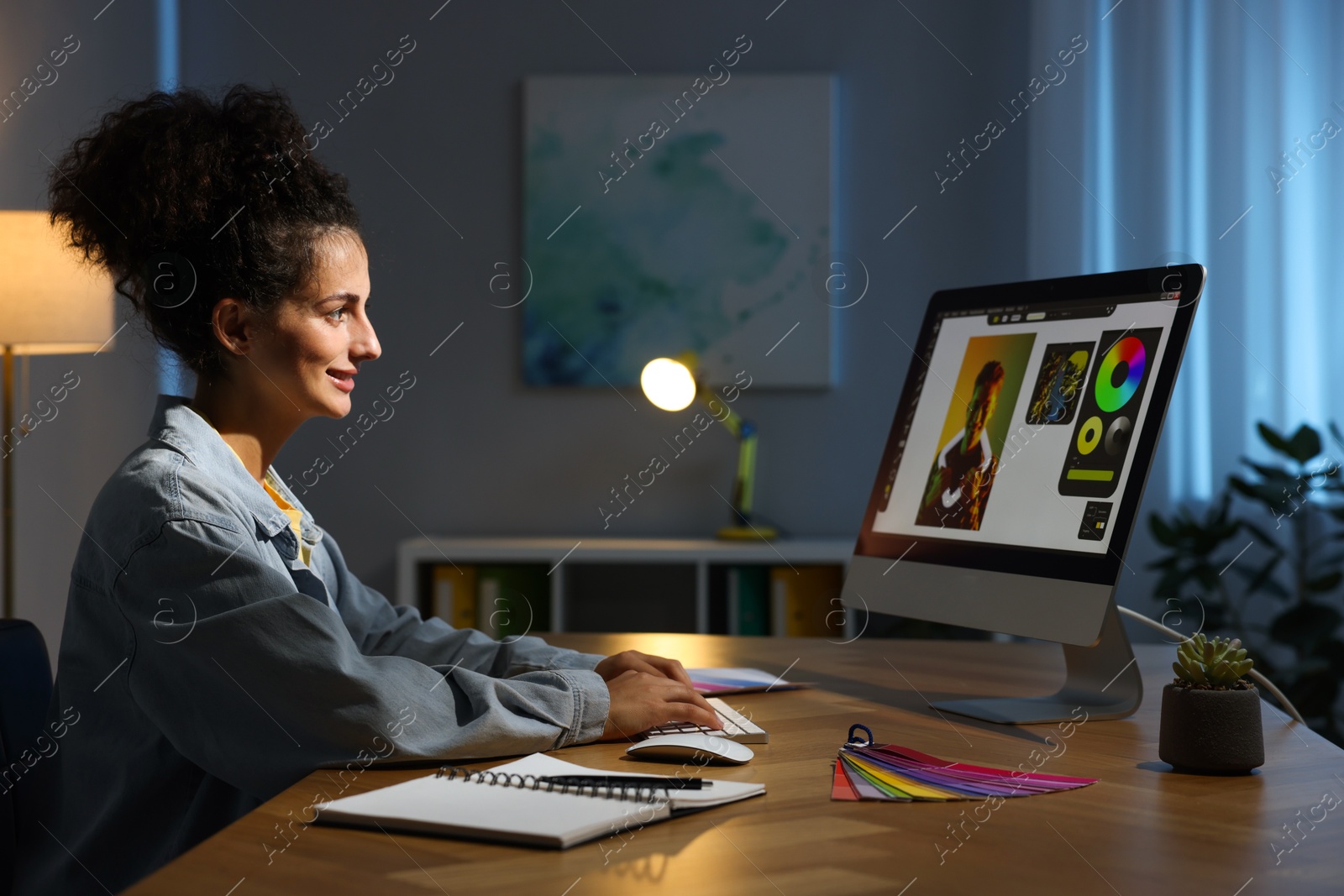 Photo of Designer working on computer indoors at night