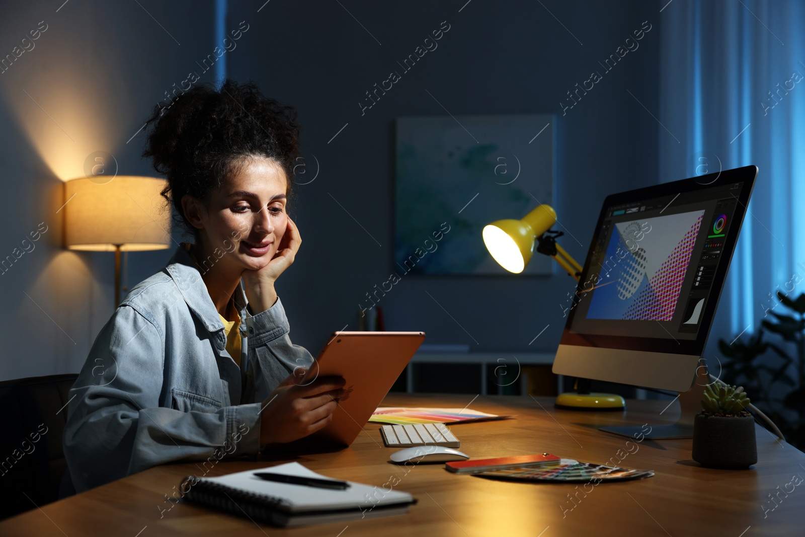 Photo of Designer working on tablet indoors at night