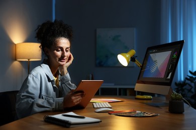 Photo of Designer working on tablet indoors at night