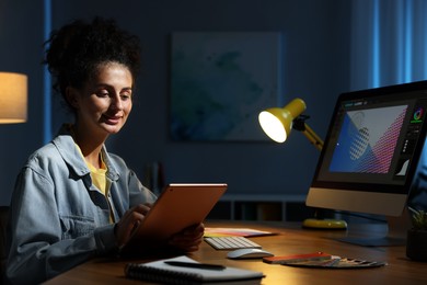 Photo of Designer working on tablet indoors at night