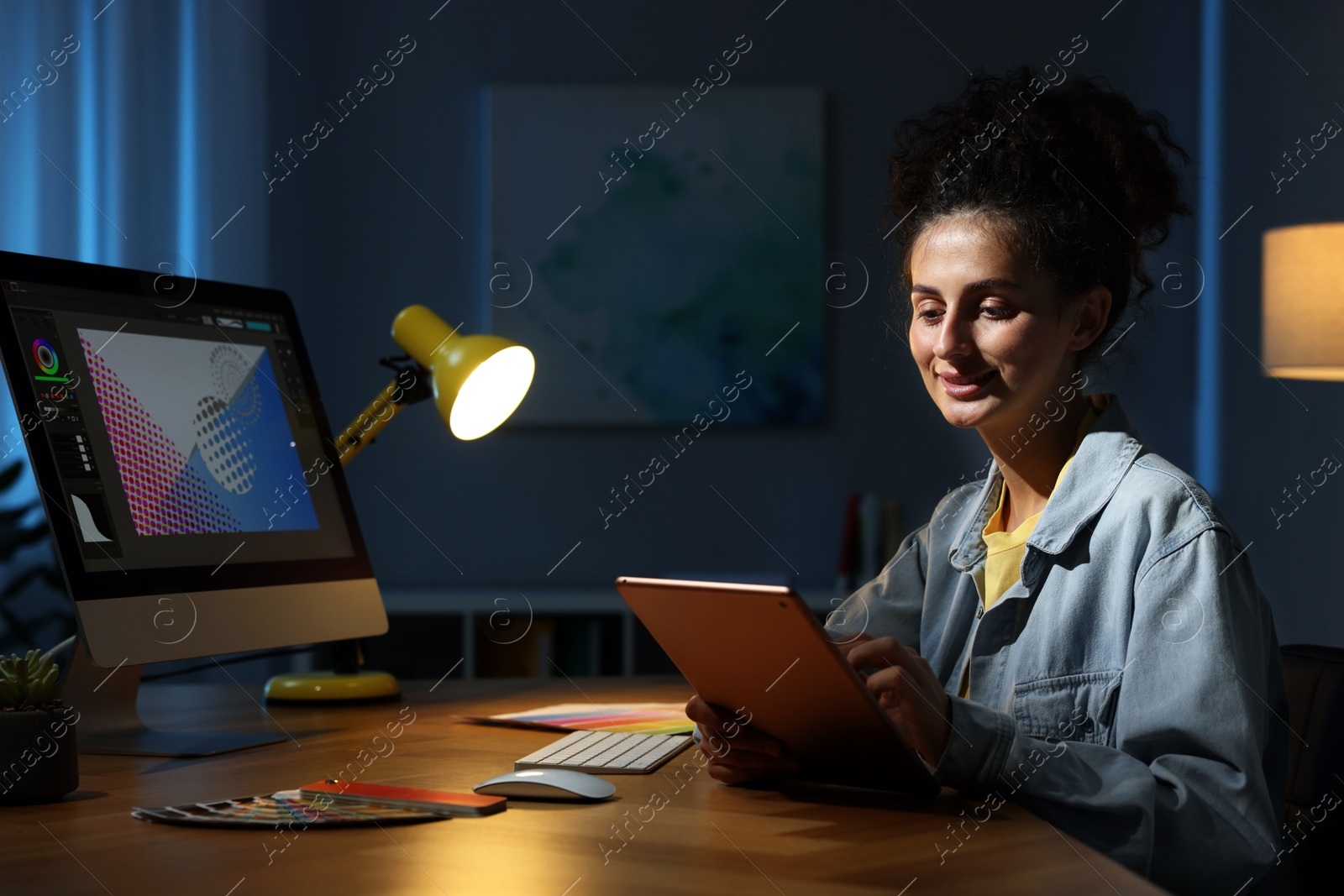 Photo of Designer working on tablet indoors at night