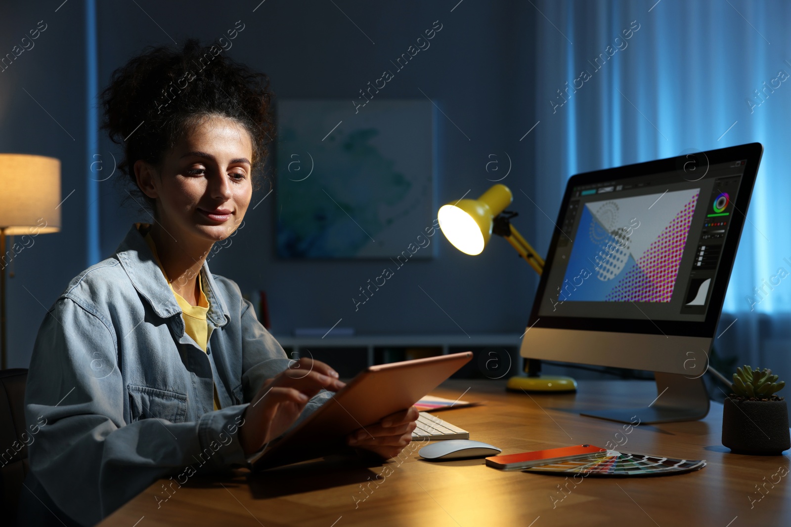 Photo of Designer working on tablet indoors at night