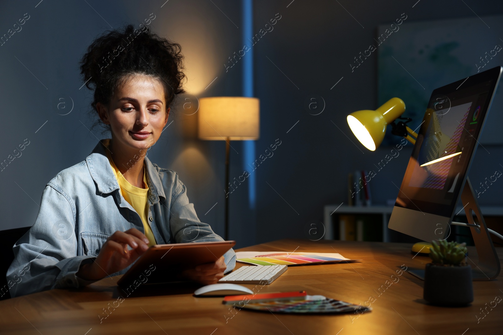 Photo of Designer working on tablet indoors at night