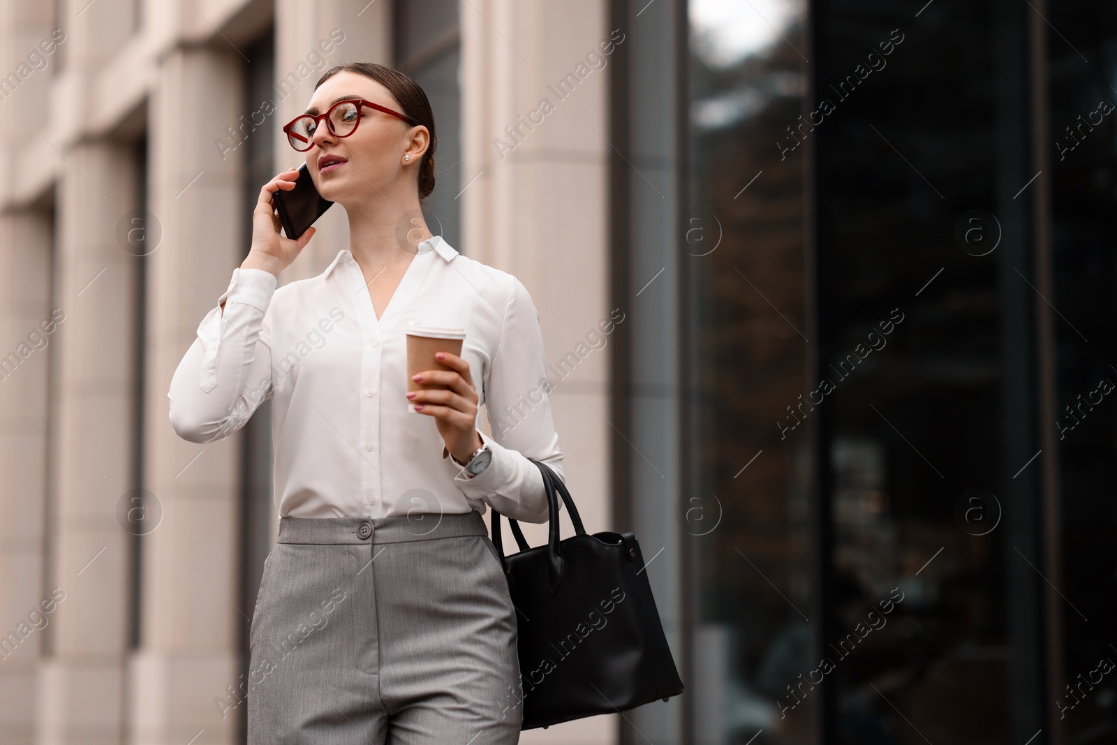 Photo of Woman in stylish outfit talking on phone outdoors. Space for text