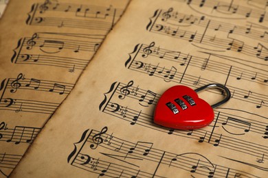 Photo of Heart shaped padlock on musical notes, closeup