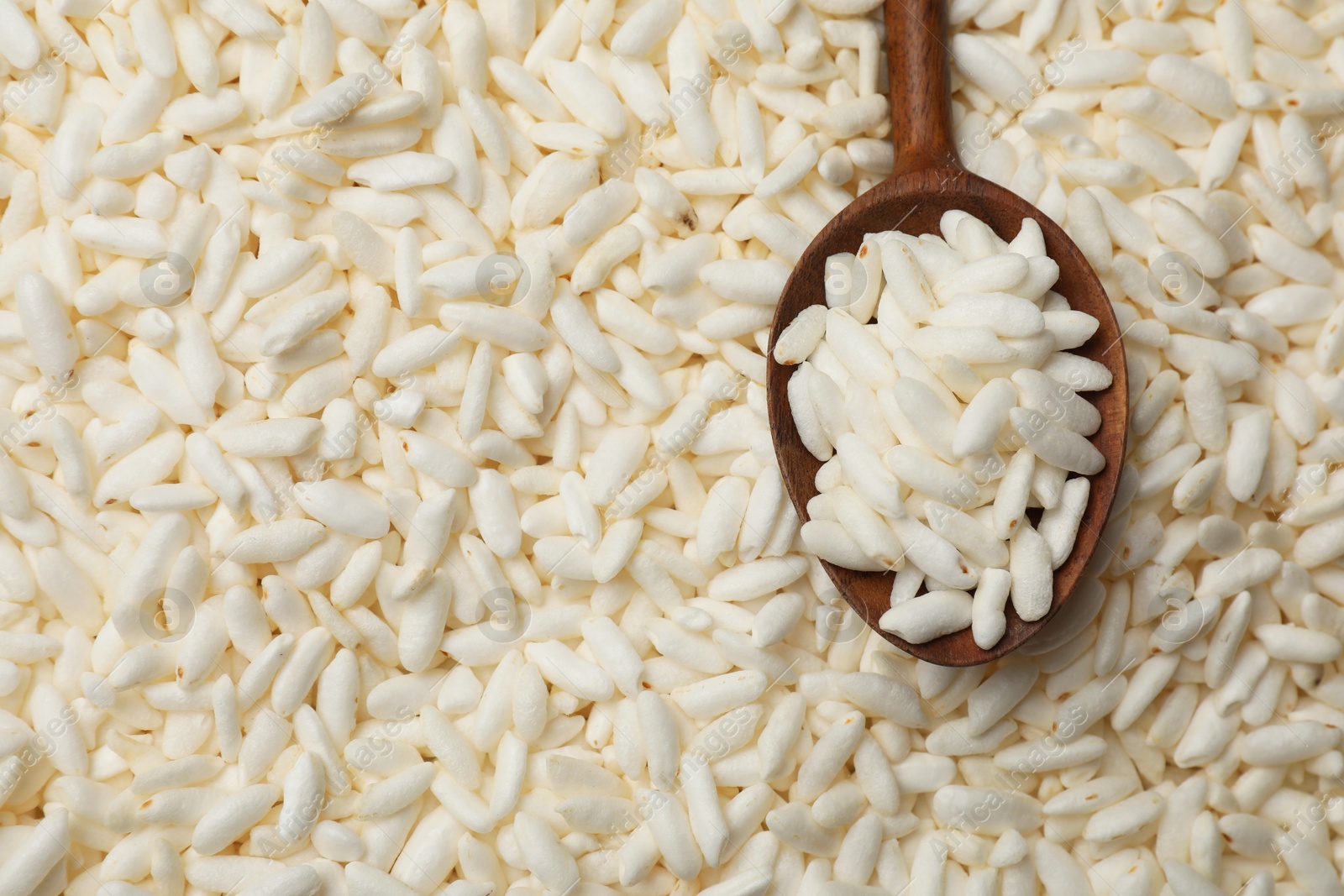 Photo of Spoon with puffed rice as background, closeup