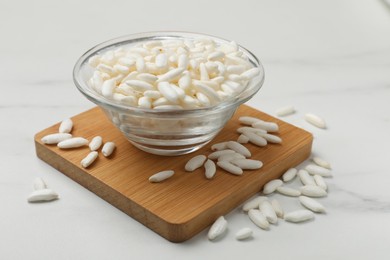 Photo of Puffed rice in bowl on white table, closeup