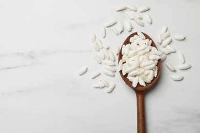 Photo of Spoon with puffed rice on white table, top view. Space for text