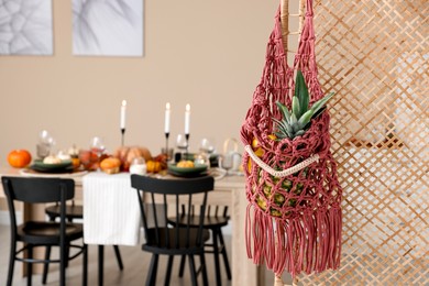 Photo of Macrame bag with fruits on folding screen indoors