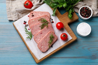 Photo of Pieces of tasty canned meat, dill, spices and tomatoes on light blue wooden table, flat lay