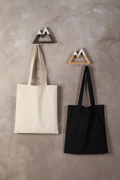 Photo of Eco bags hanging on grey wall. Mockup for design