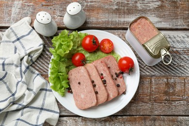 Photo of Tasty canned meat, tomatoes, lettuce and spices on wooden table, top view