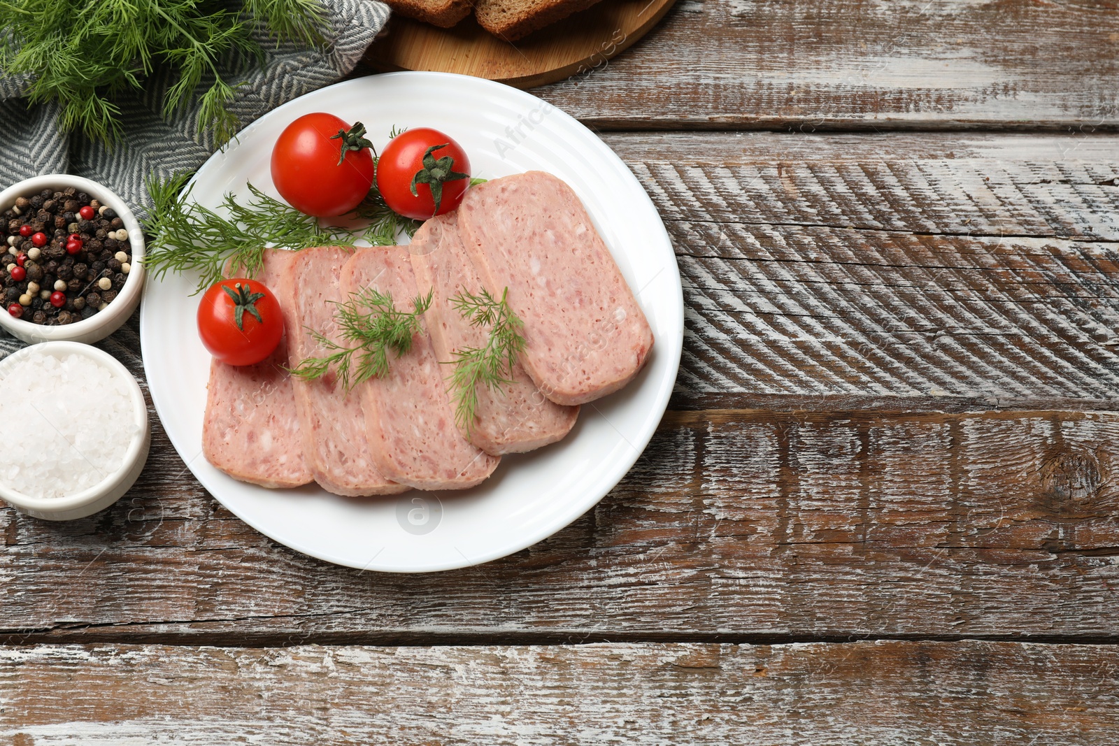 Photo of Tasty canned meat, tomatoes and spices on wooden table, flat lay. Space for text