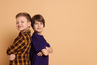 Photo of Portrait of cute brothers on beige background. Space for text