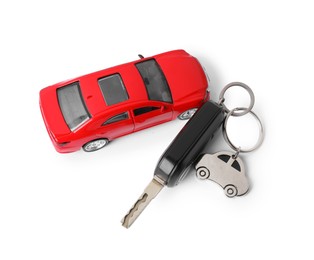 Photo of Car key with keychain and toy isolated on white, top view. Buying auto