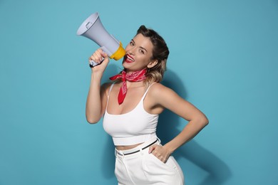 Photo of Excited pin-up woman shouting in megaphone on light blue background