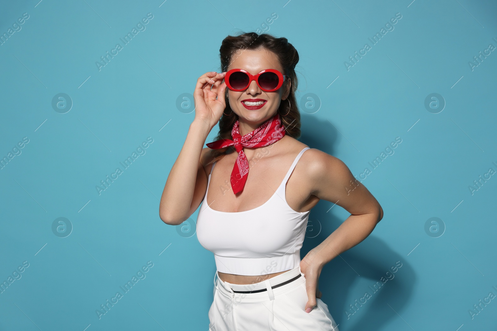 Photo of Happy pin-up woman on light blue background