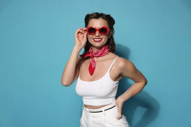 Photo of Happy pin-up woman on light blue background