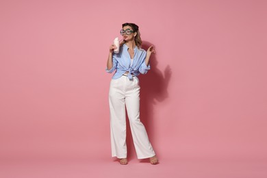 Photo of Attractive pin-up woman with milk shake on pink background