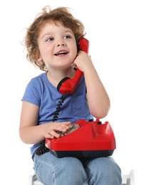 Photo of Cute little boy with telephone on stool against white background