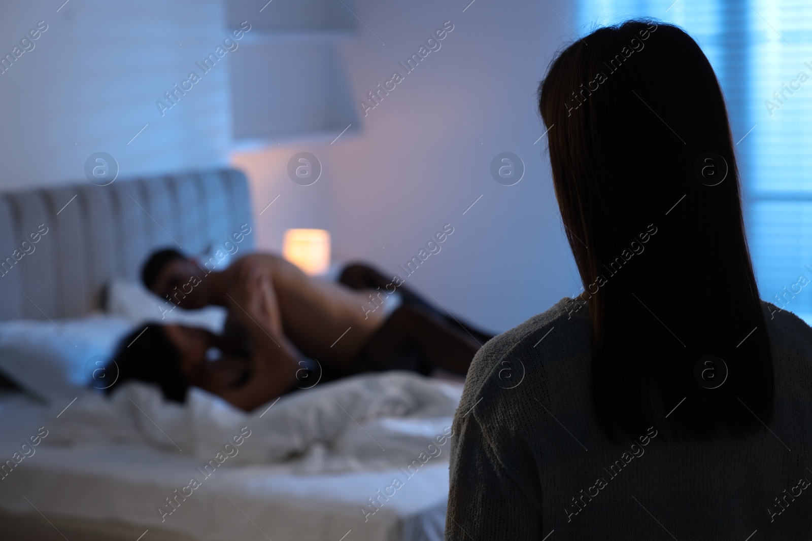 Photo of Betrayal. Wife catching her husband with mistress in bed at home, selective focus