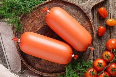 Photo of Tasty boiled sausages, tomatoes and dill on wooden table, top view