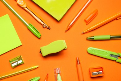 Photo of Different stationery on orange background, flat lay