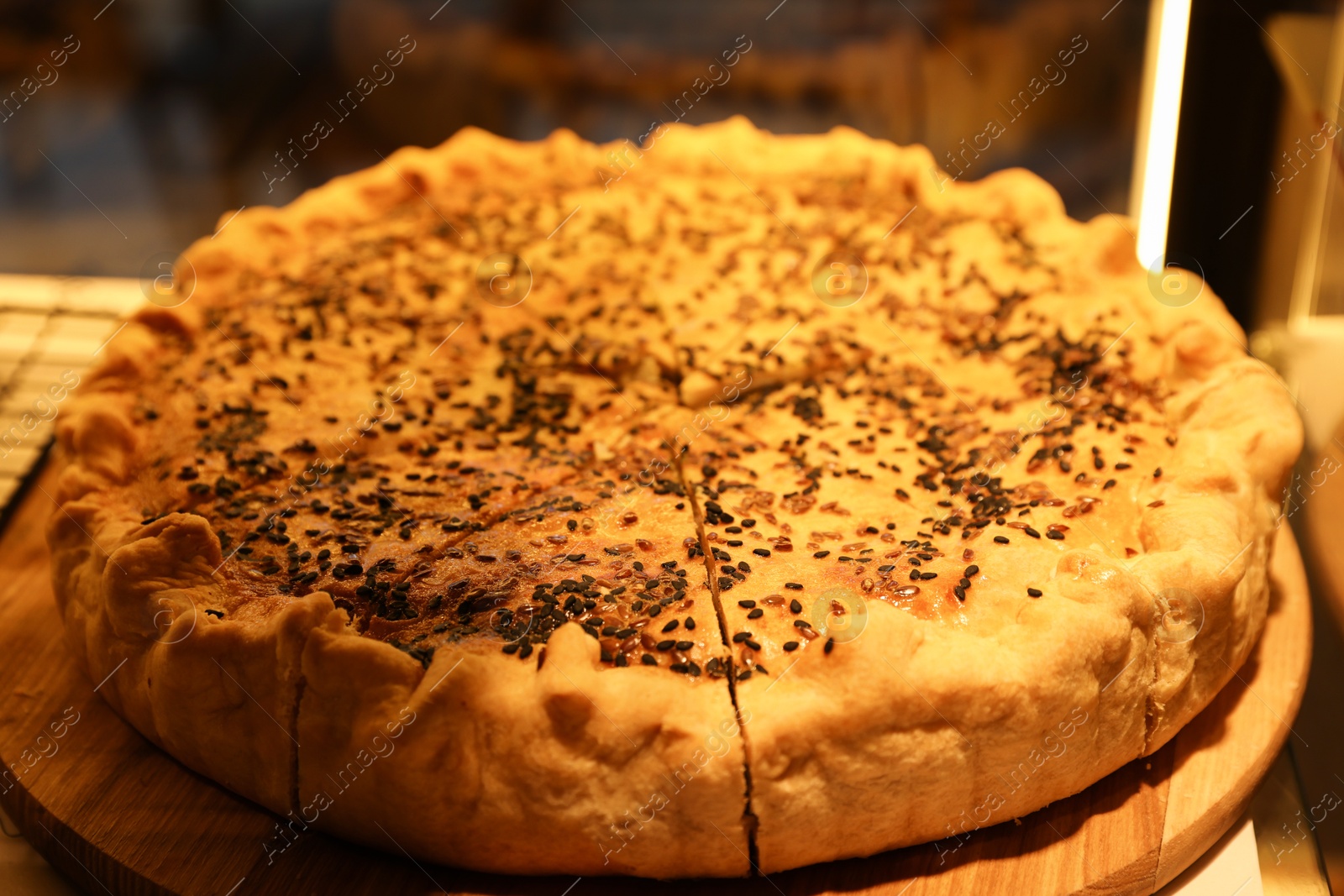 Photo of Delicious pie with sesame seeds on display in cafe, closeup