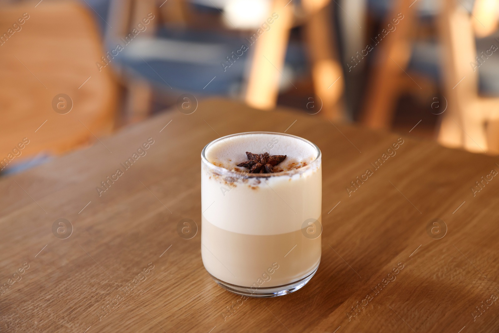 Photo of Glass of aromatic coffee on wooden table in cafe, closeup